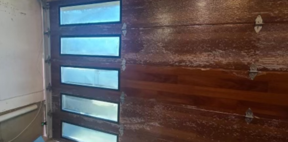 A close up of a wooden garage door with glass windows.