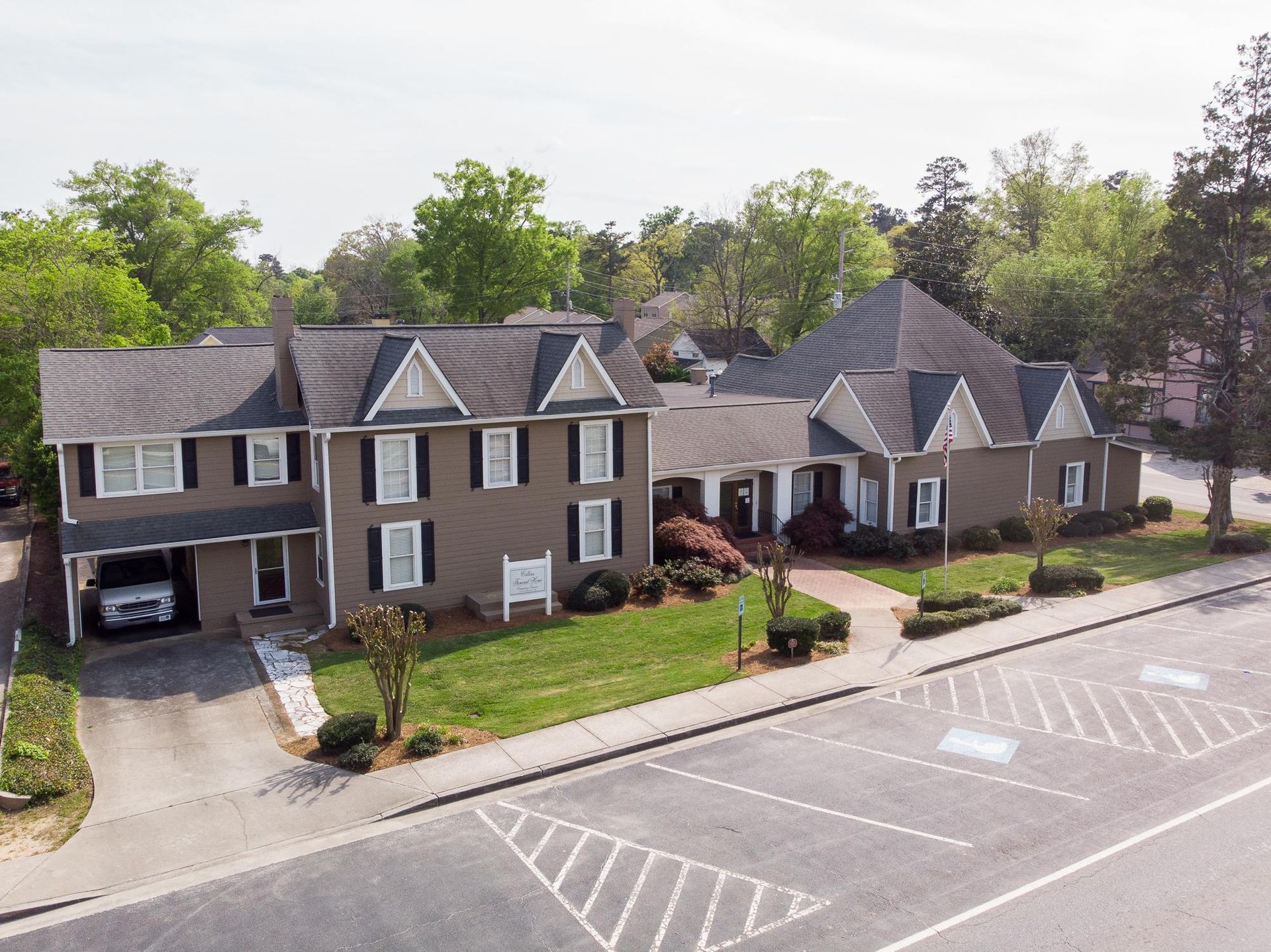 Aerial view of a large suburban townhouse complex with parking spaces and trees
