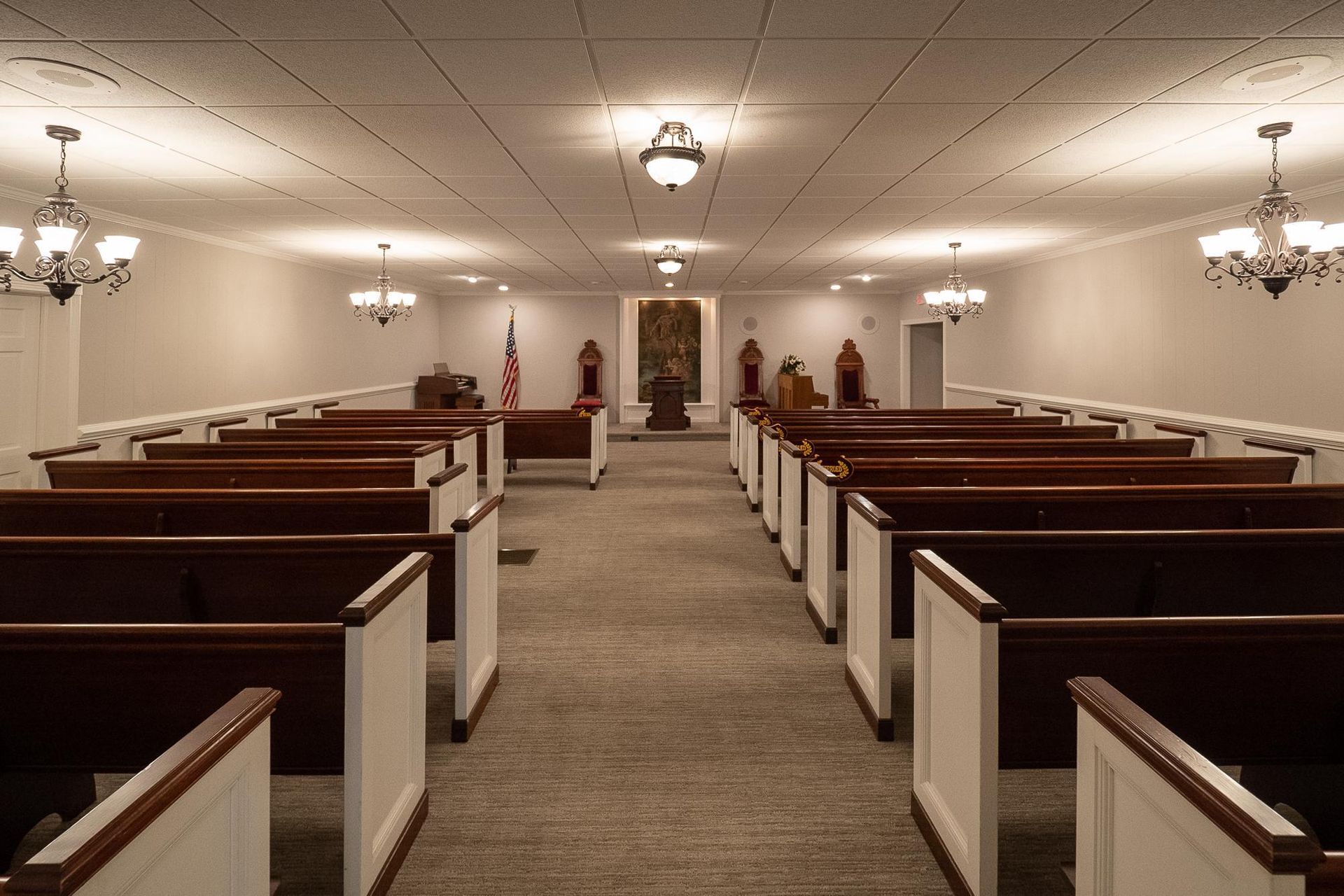 Empty church sanctuary with rows of wooden pews and a central aisle leading to the altar