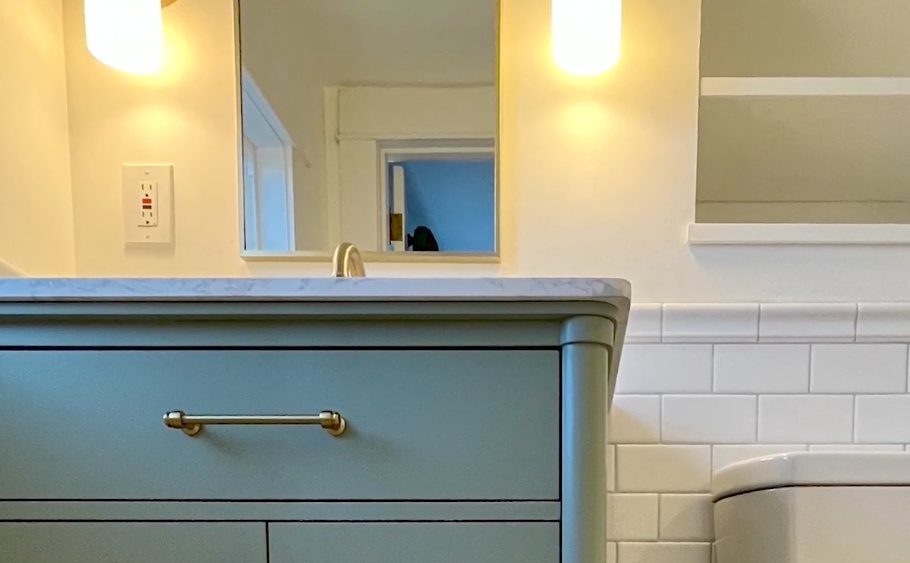 New vanity and sink in a brightly lit, clean bathroom, showcasing the improved organization and storage systems.
