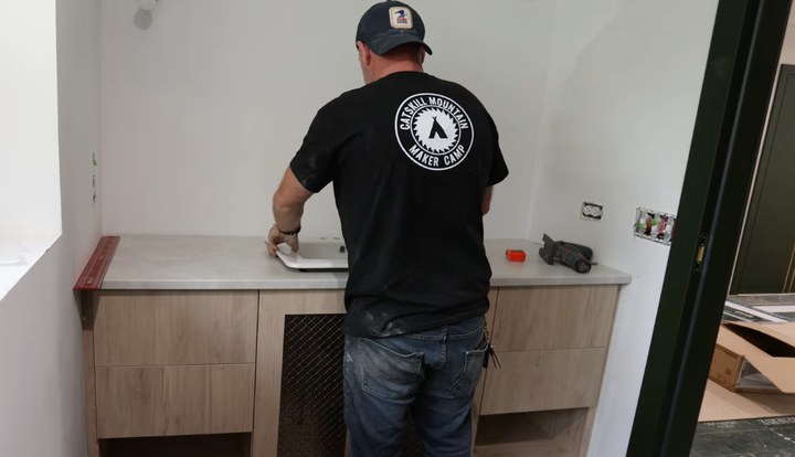 Contractor carefully replacing the bathroom sink and vanity for a new one with a clean, sleek look.