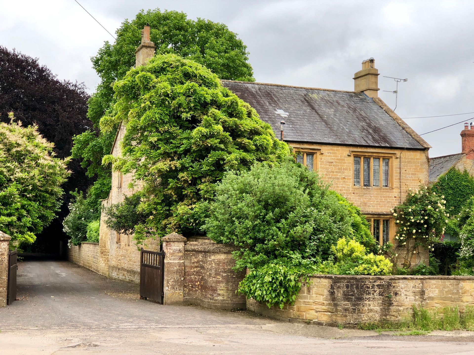 A brick house with a driveway leading to it