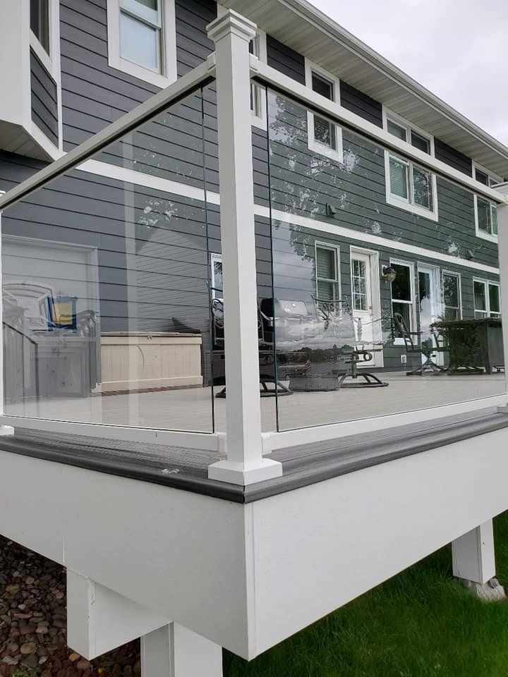 A large house with a glass railing on the deck.