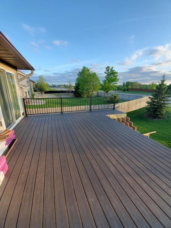 A large wooden deck with a railing is sitting on top of a house.