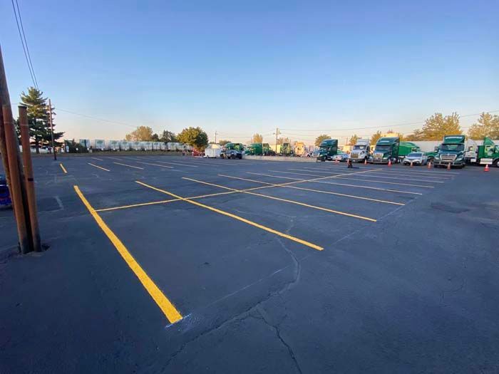 Parking lot with yellow painted lines and several trucks.