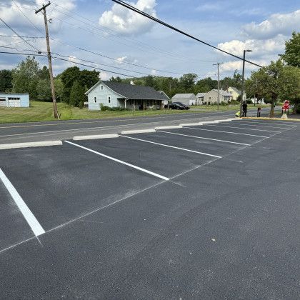 Newly paved parking lot with white painted parking space lines.