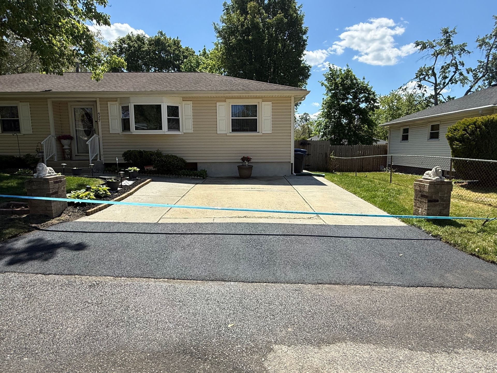 Single-story house with a driveway, sidewalk, lawn, and a person on the front porch