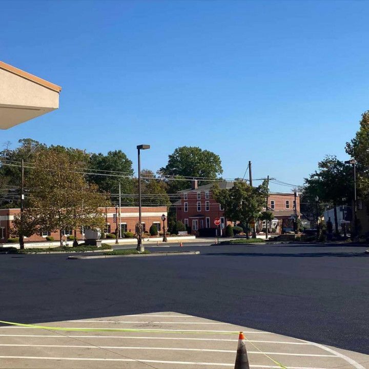 Street scene with businesses and trees under a clear blue sky.