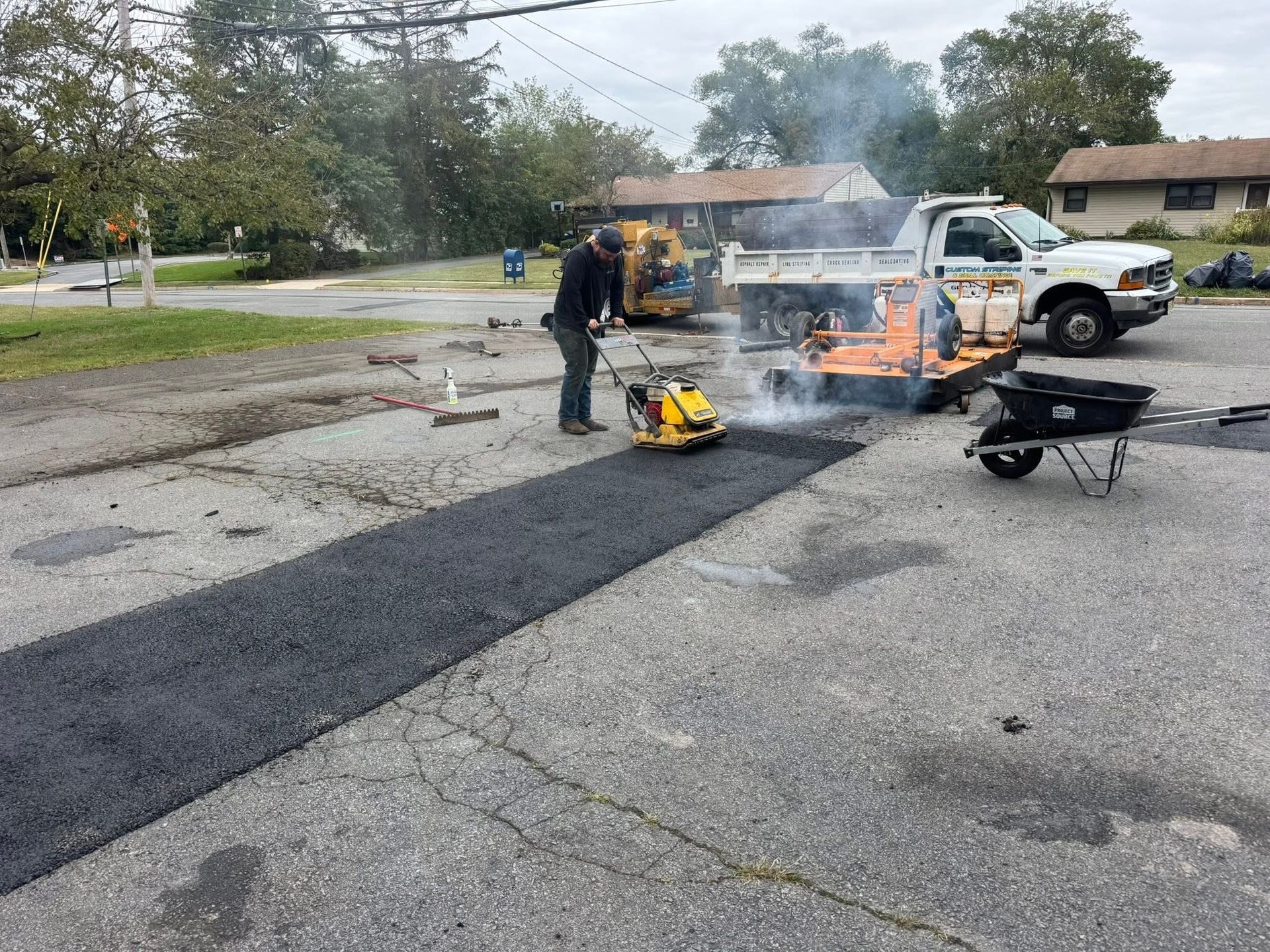 Firefighters dousing a truck fire on a wet street with smoke and flames visible