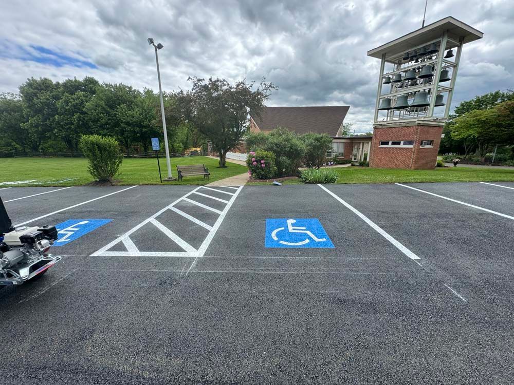 Accessible parking spaces marked in blue, with a church and bell tower in the background.
