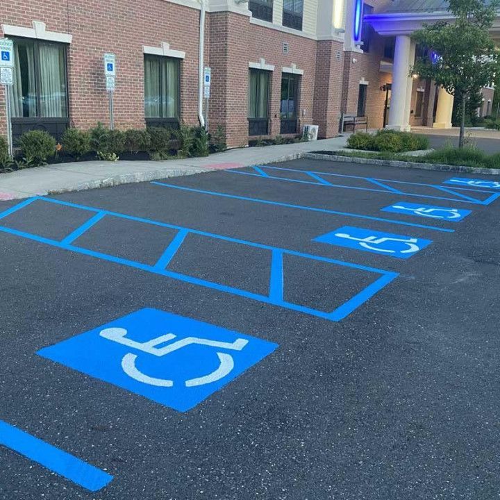 Blue painted handicap parking spaces at a building's entrance.