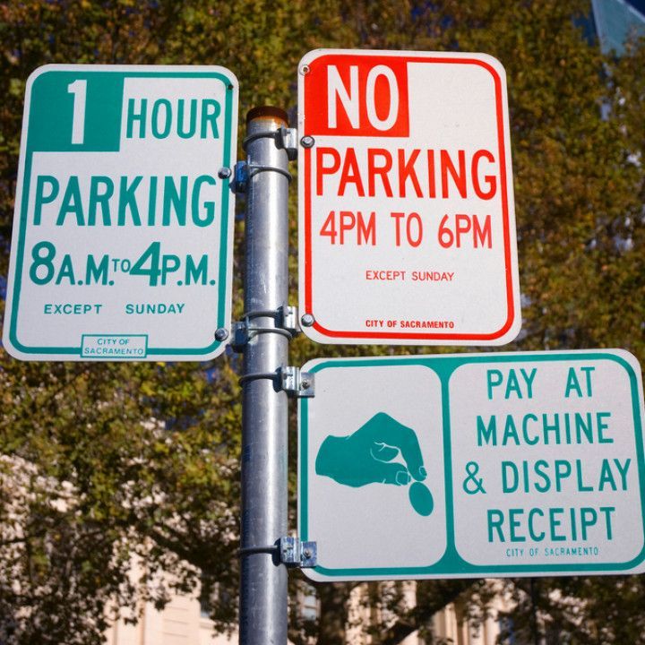Parking signs: 1-hour parking (8 AM-4 PM, except Sunday), no parking (4 PM-6 PM, except Sunday), pay-at-machine.