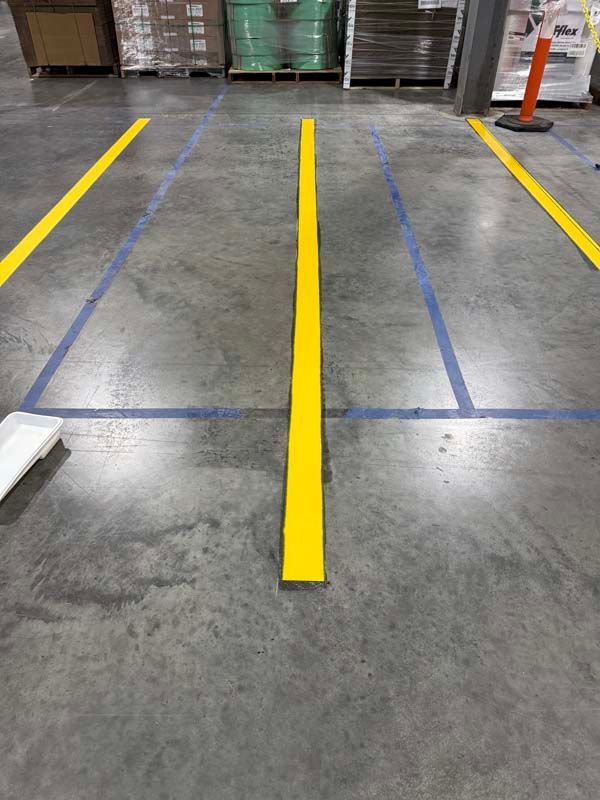 Warehouse floor marked with yellow and blue lines, defining pathways and boundaries.