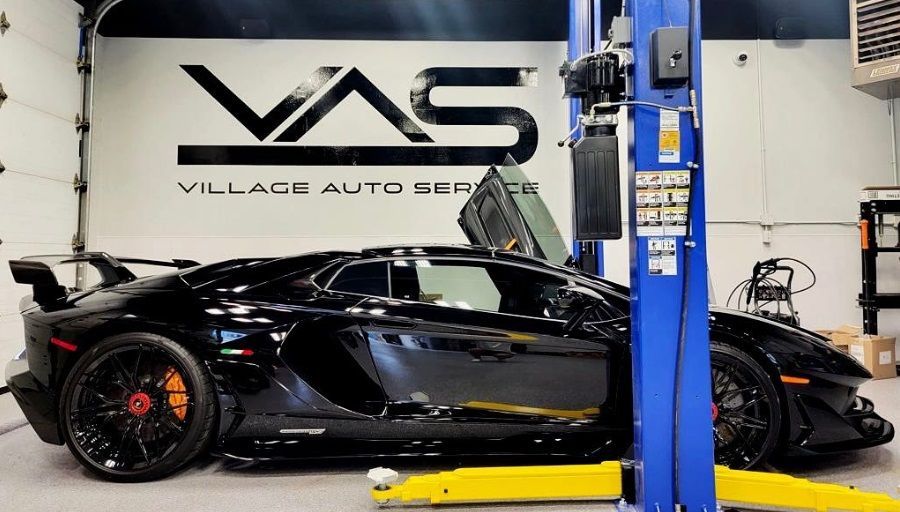 Black Lamborghini car parked inside of Village Auto Service for automotive repairs