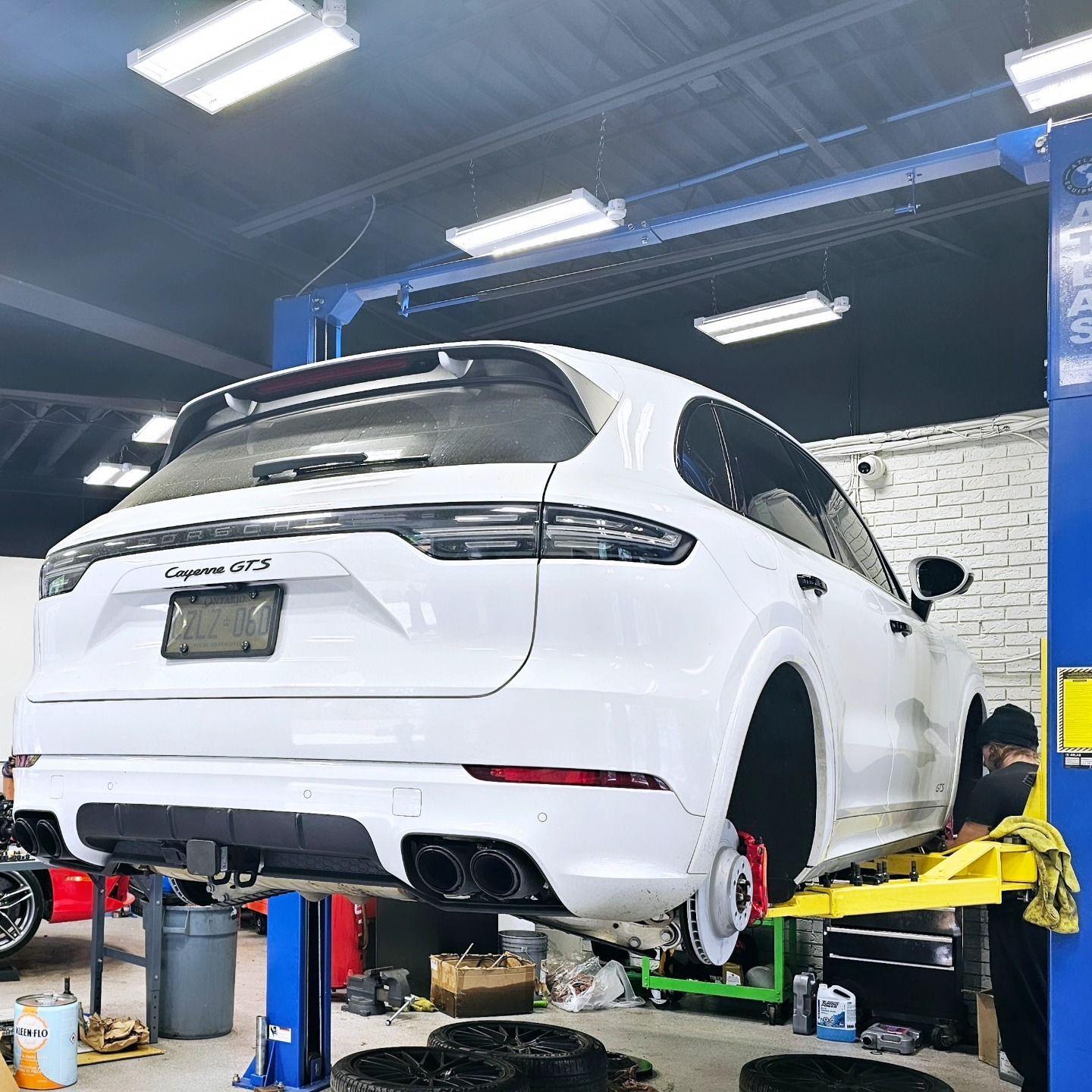 White Porsche Cayenne GTS getting tire service at Village Auto Service