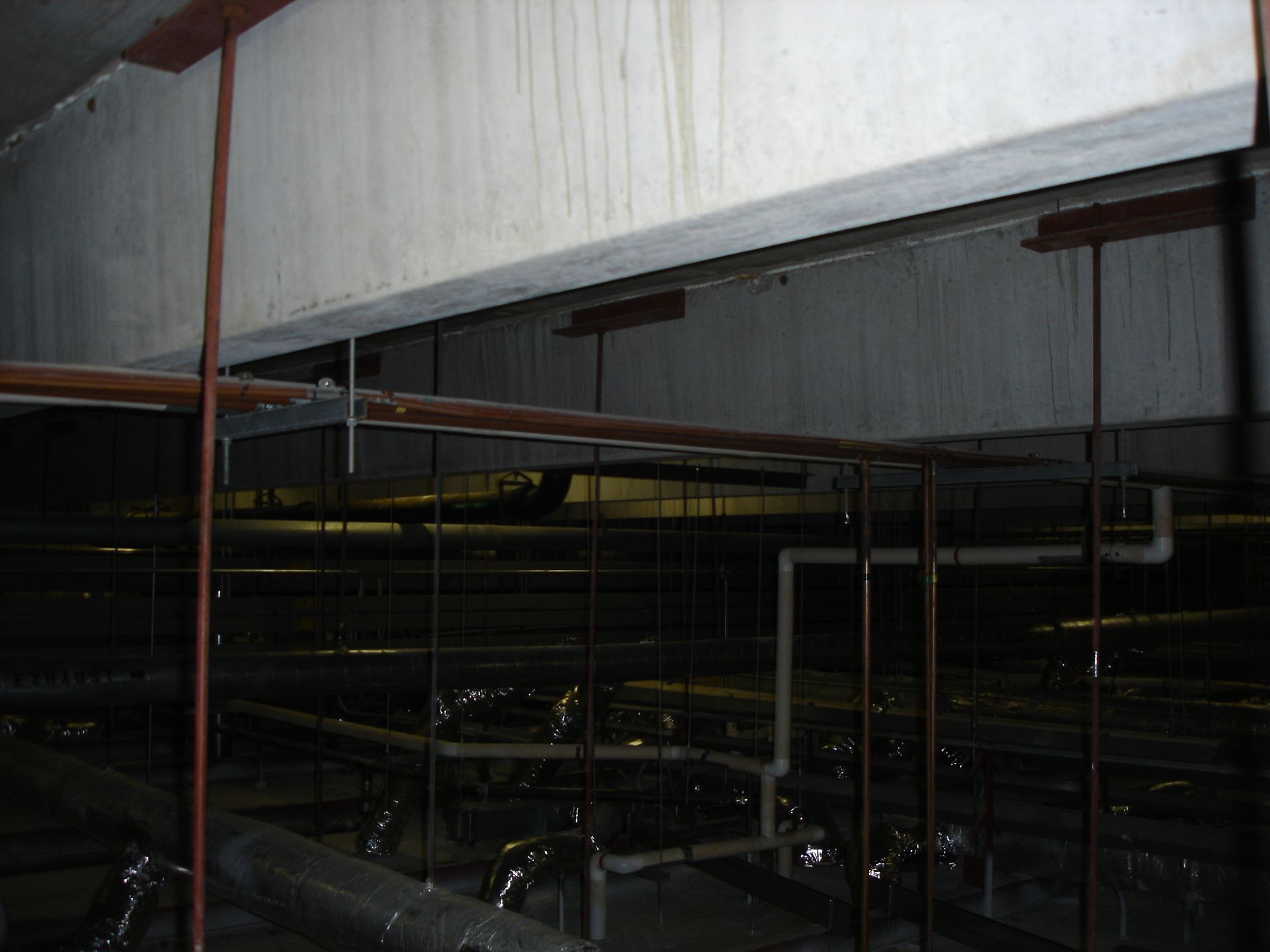 A dark room with pipes hanging from the ceiling
