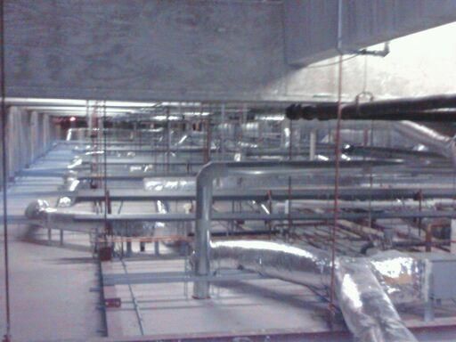 A room with a lot of pipes hanging from the ceiling