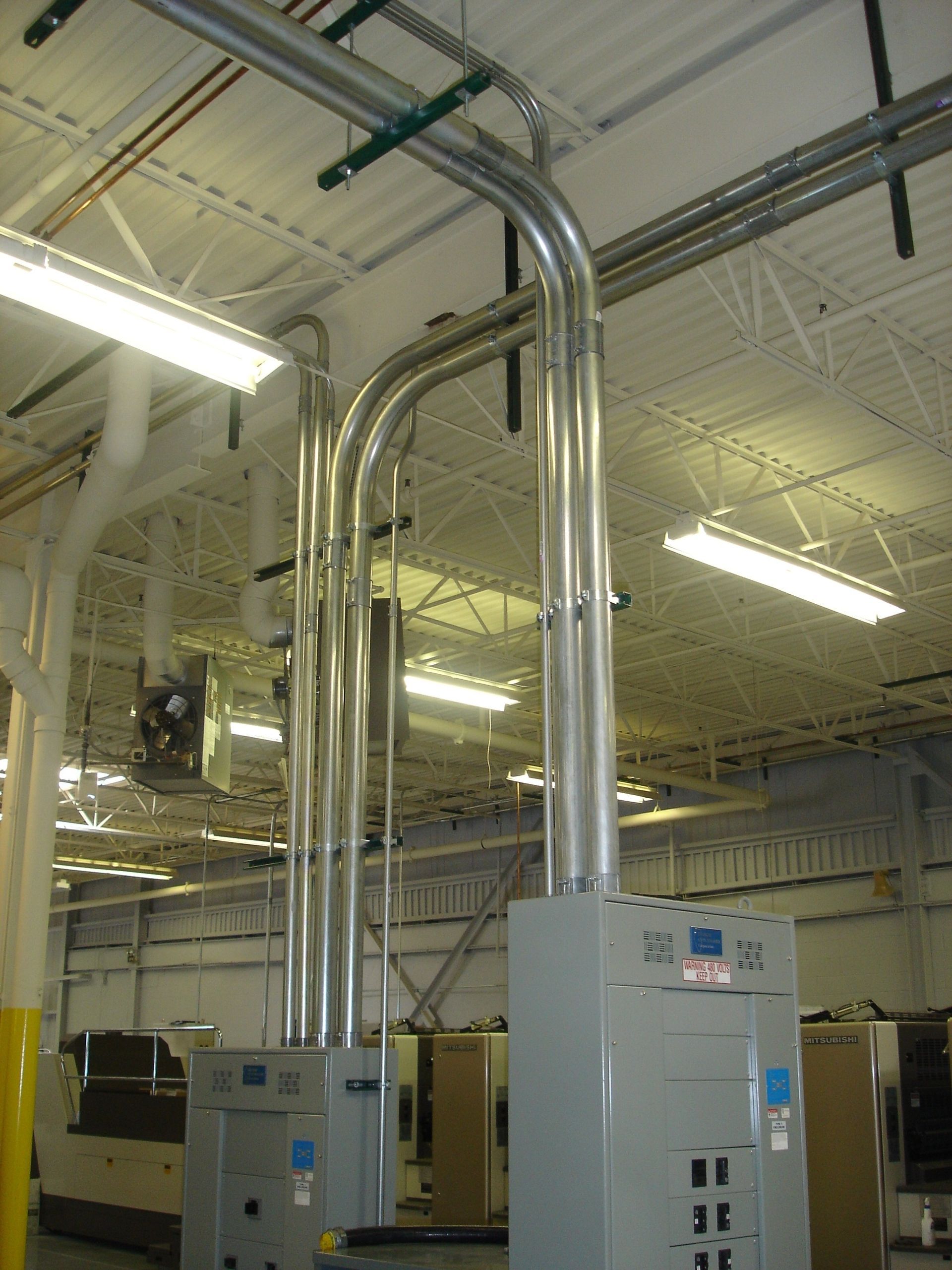 A large room with a lot of pipes and a box that says ' electrical ' on it