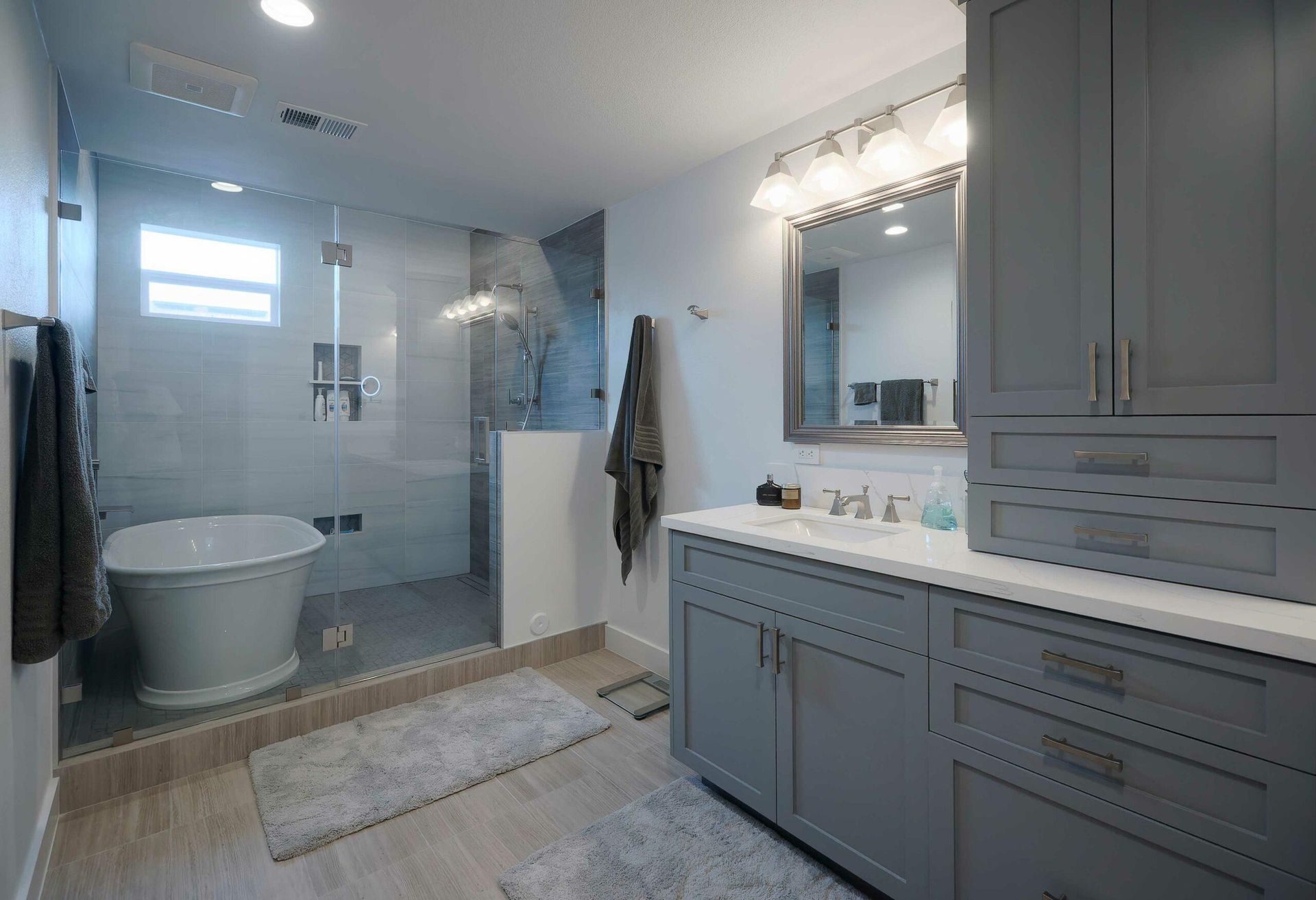 A bathroom with a tub , sink , mirror and walk in shower.