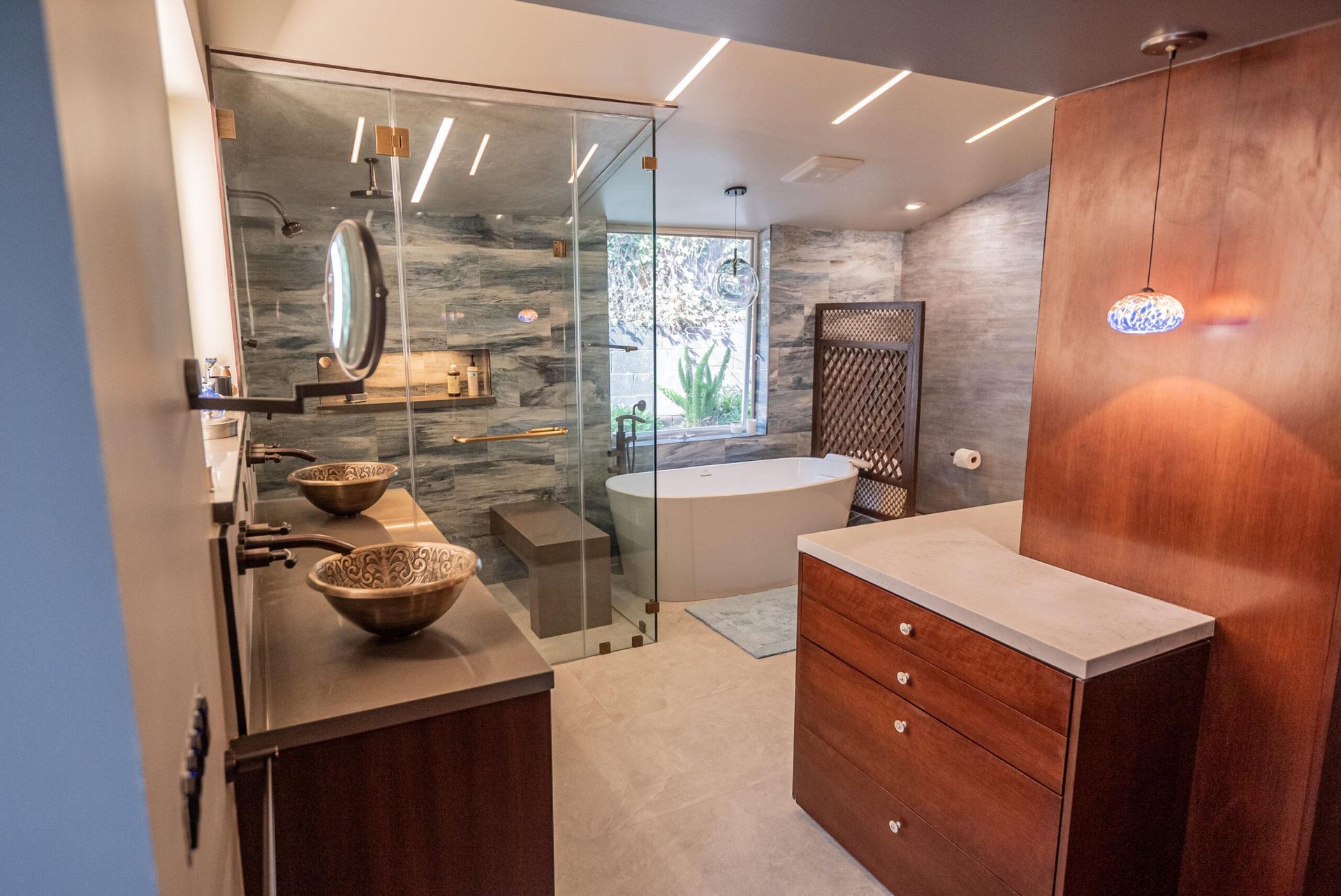 A bathroom with two sinks , a tub , and a walk in shower.