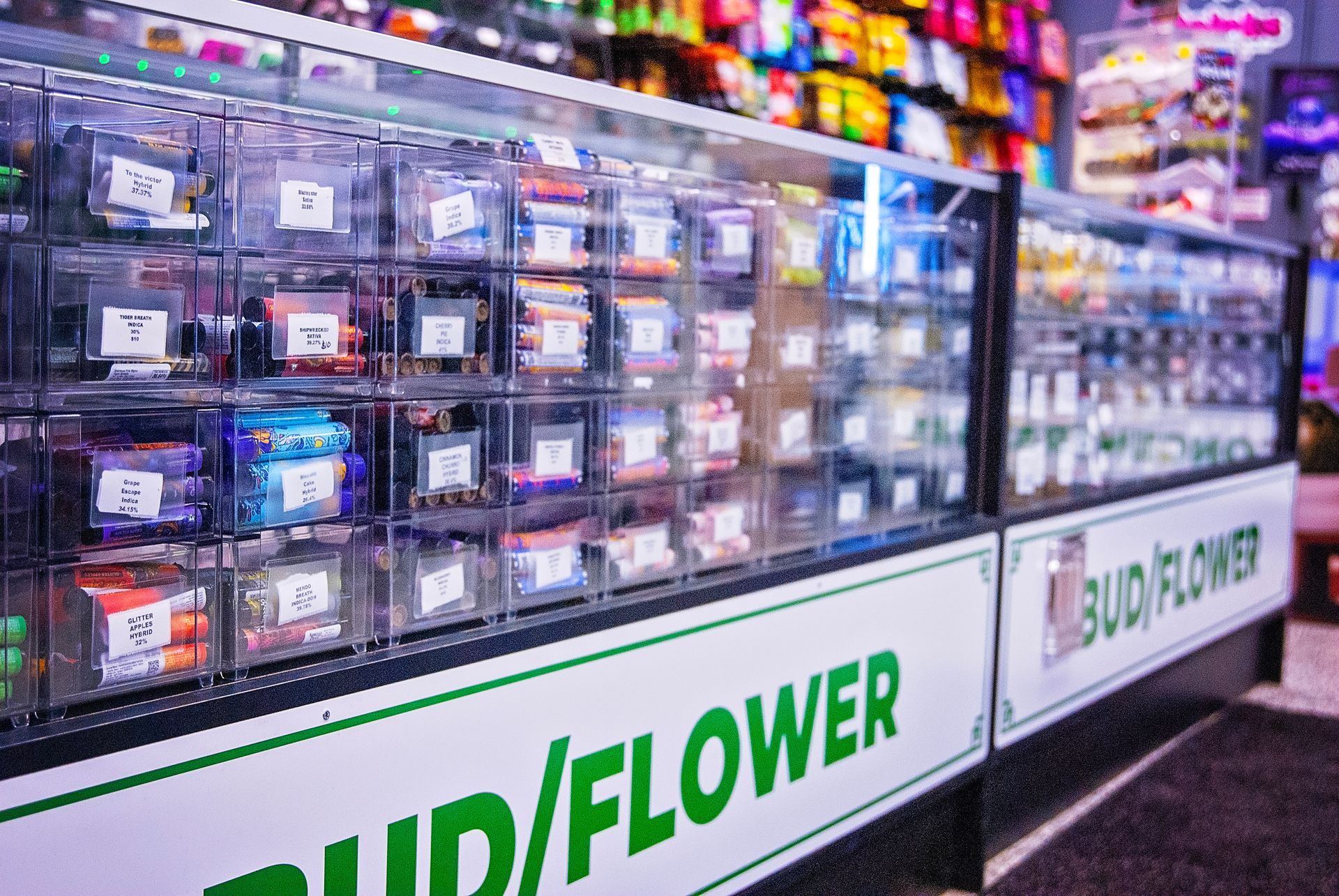 A display case in a store with a sign that says bud / flower.