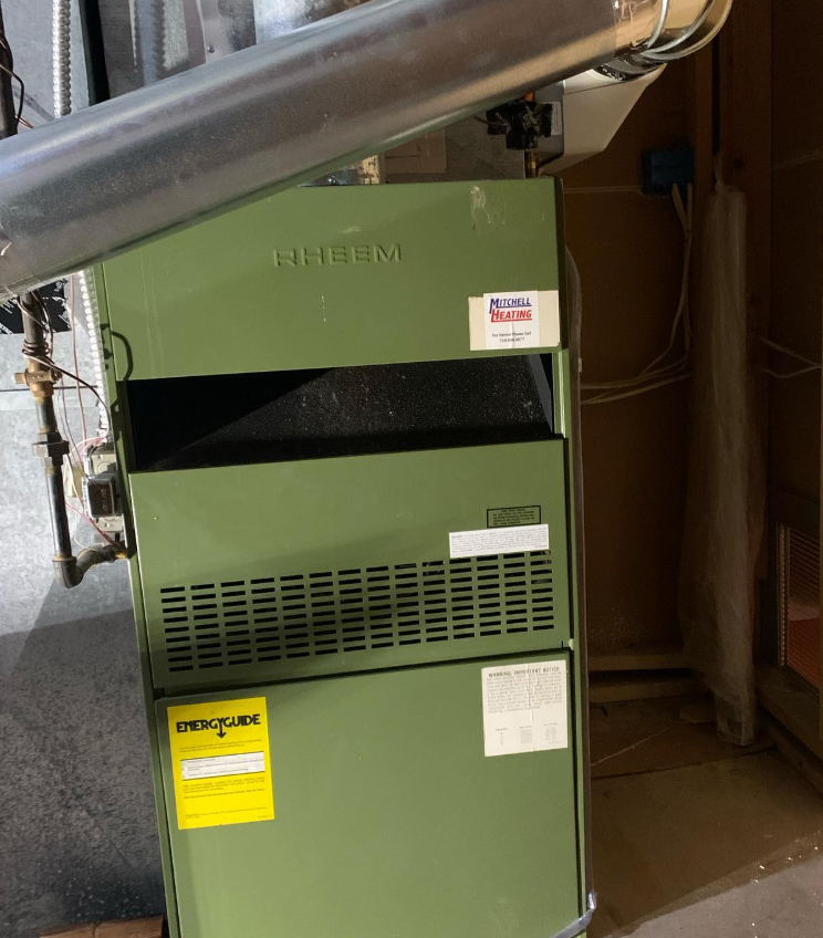 A green, Rheem furnace in a basement installed by Steen & Son Plumbing and Heating in Atlantic County, New Jersey