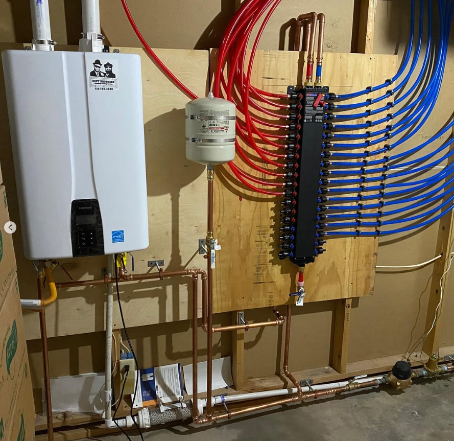 Residential plumbing manifold with red and blue PEX tubes, water heater, and wall-mounted boiler system