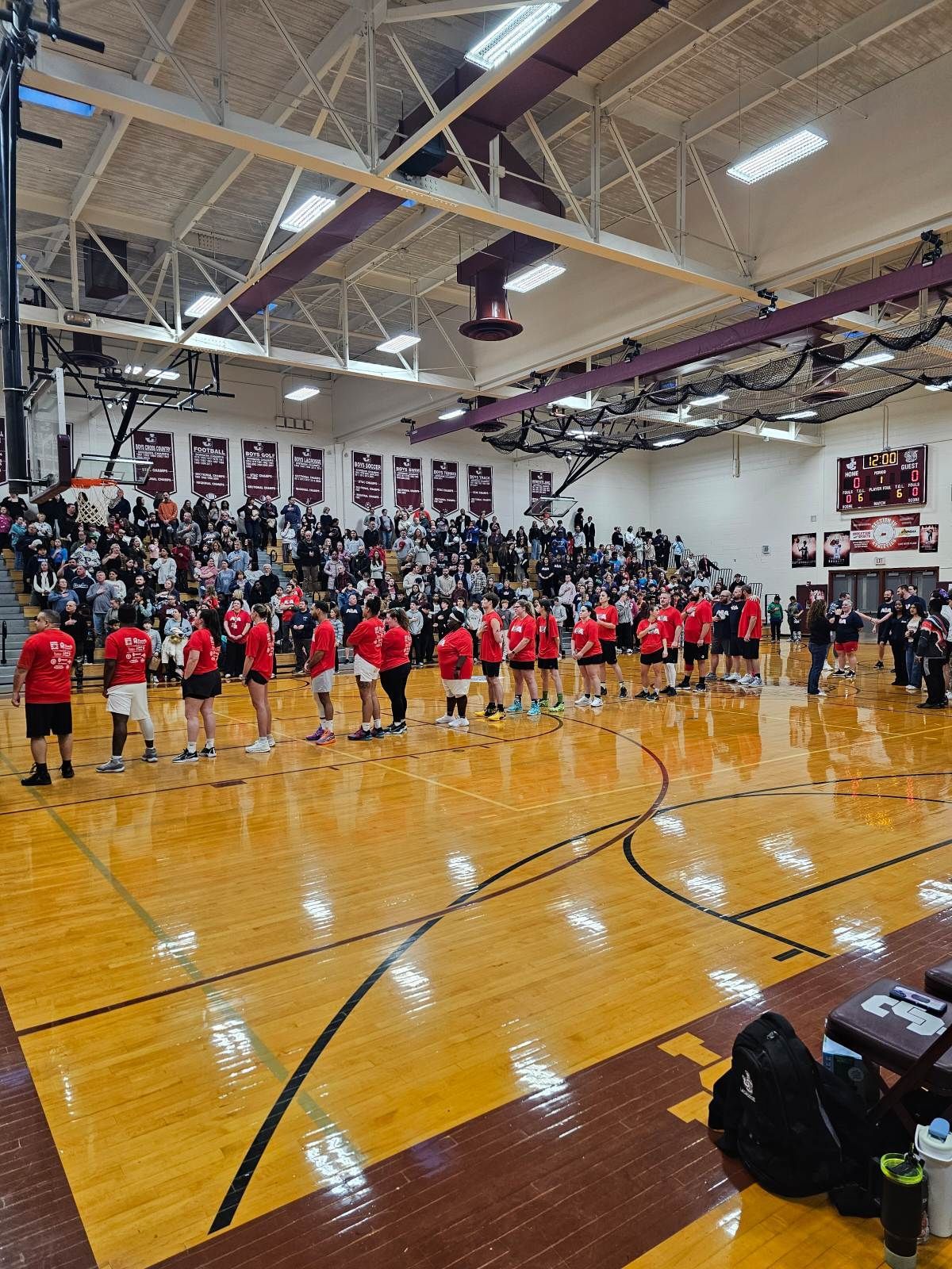 The crowd at a men's basketball game in a high school gym