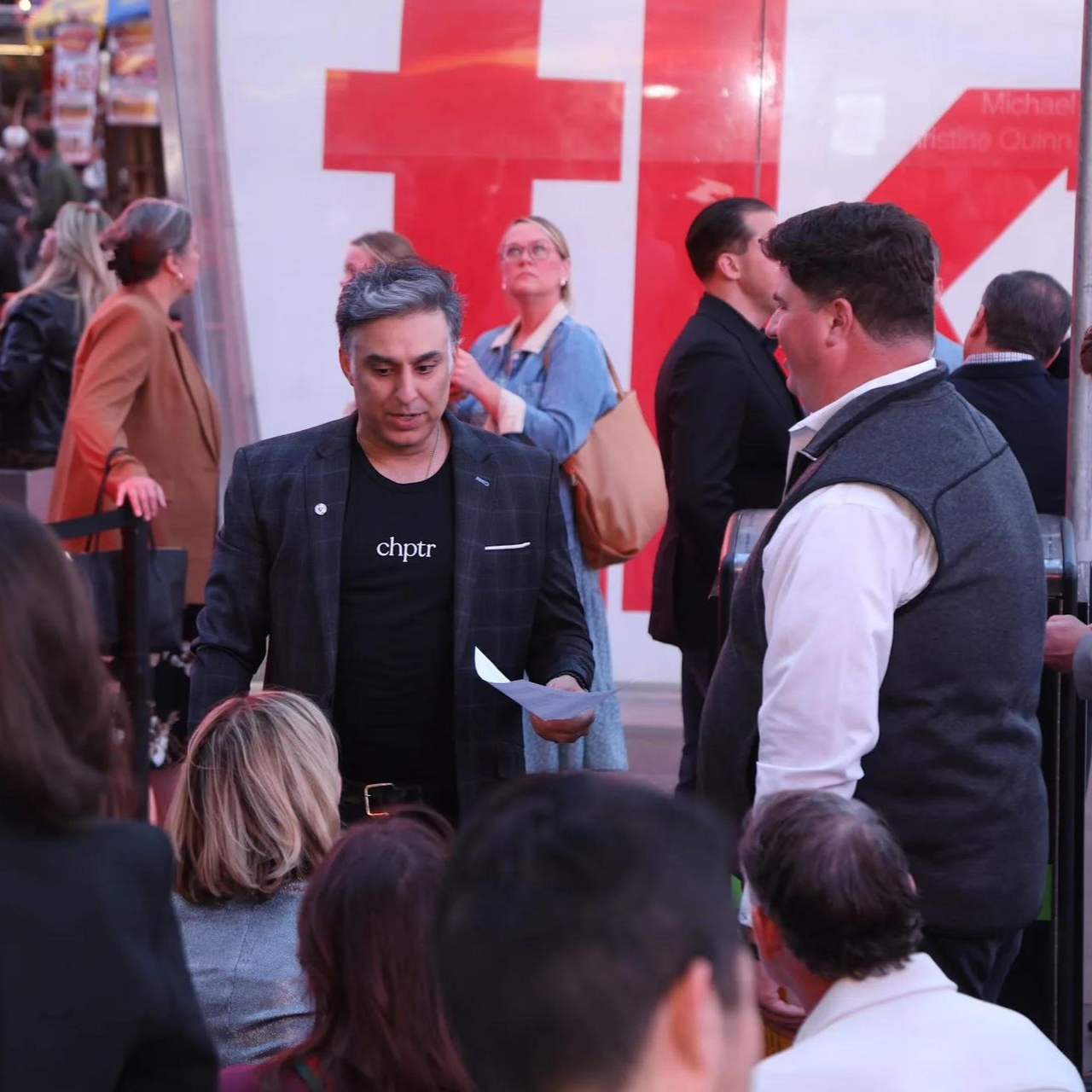 A group of people gathering at a booth at a convention