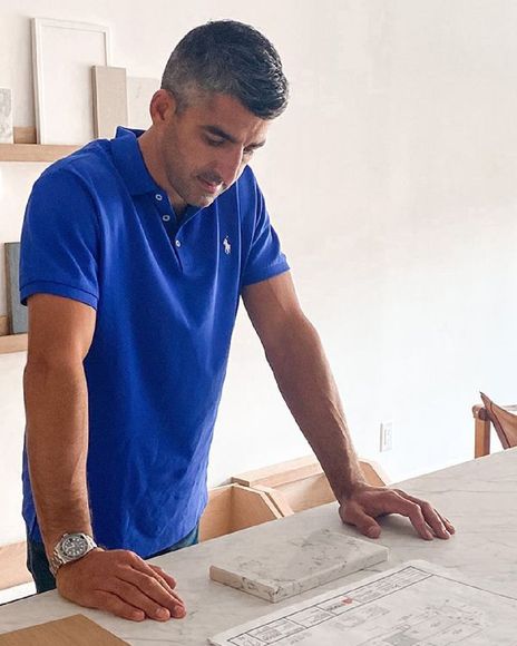 Man in blue shirt completeing architectural plans and permit drawings in Toronto