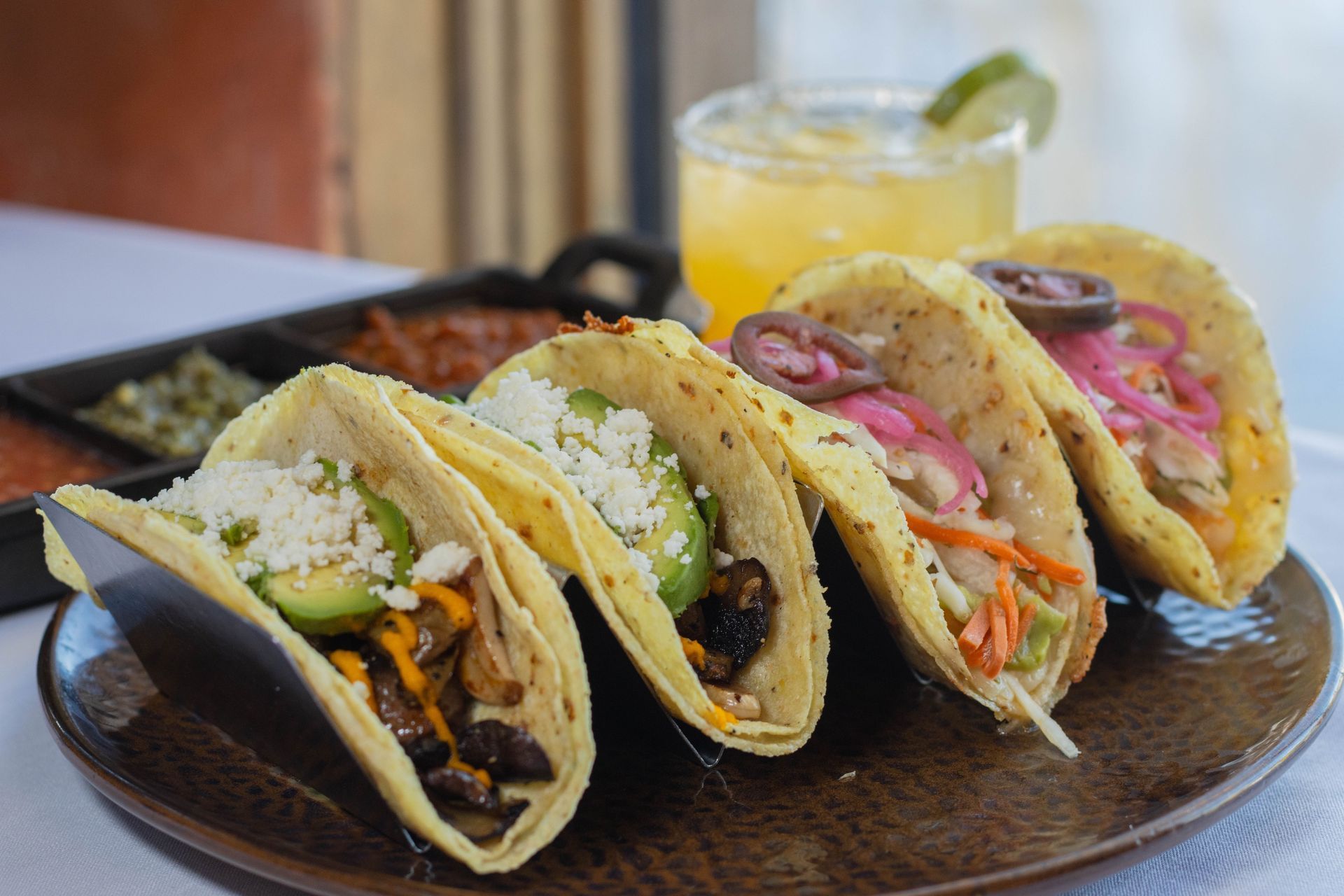 Row of soft tacos with a drink behind them at Mi Casa in Breckenridge