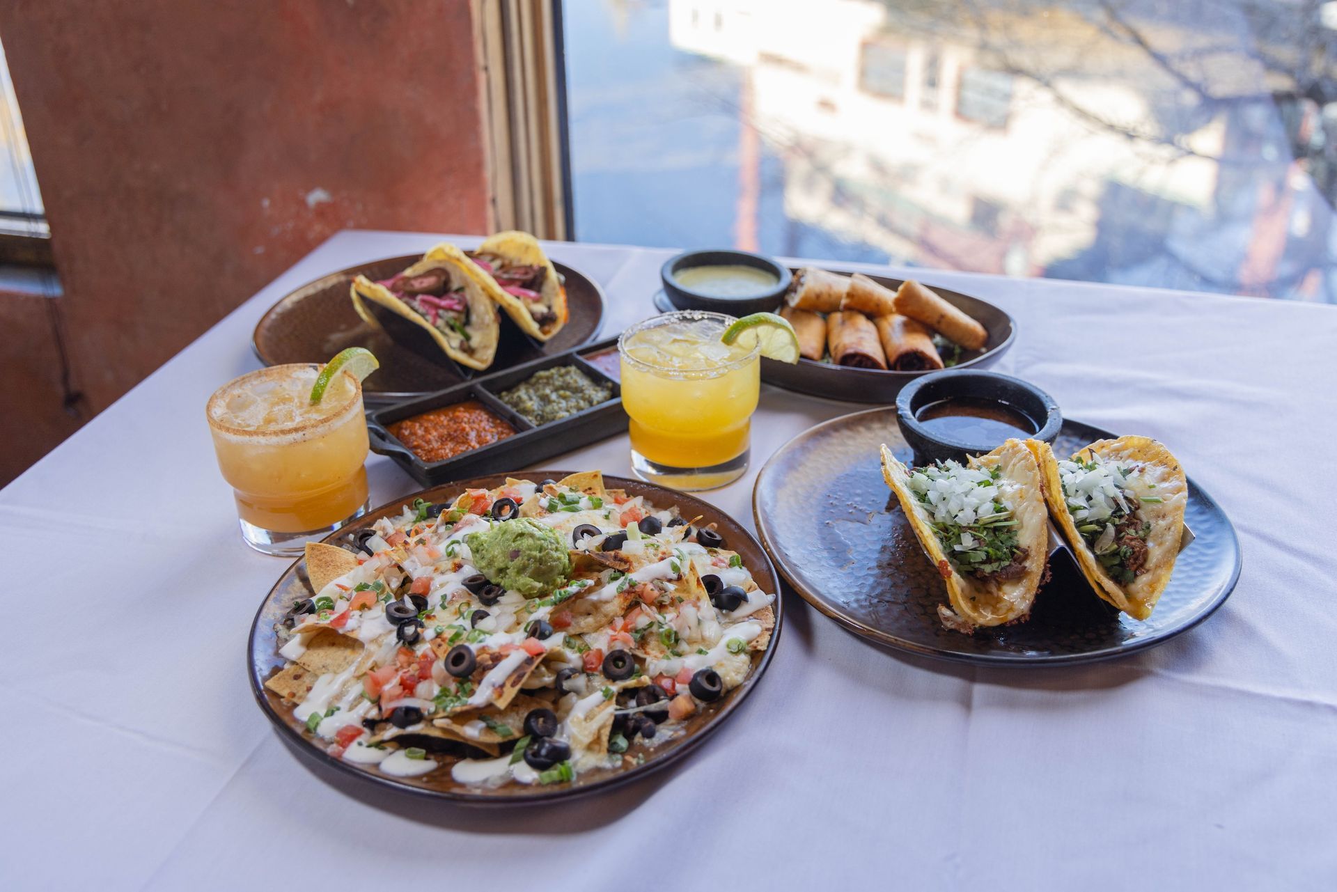 Tacos, a plate of nachos and drinks on a window table at Mi Casa in Breckenridge