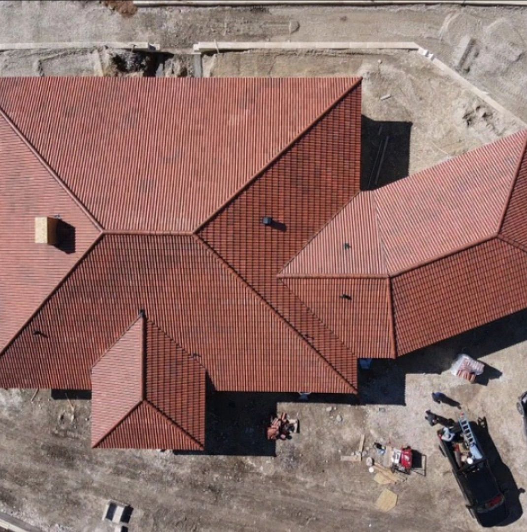 An aerial view of a house with a red tile roof