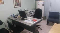 Mãos organizando papéis em um organizador de arquivos azul sobre uma mesa.