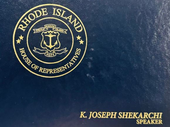 Rhode Island House of Representatives seal on blue cover with gold text reading K. Joseph Shekarchi Speaker
