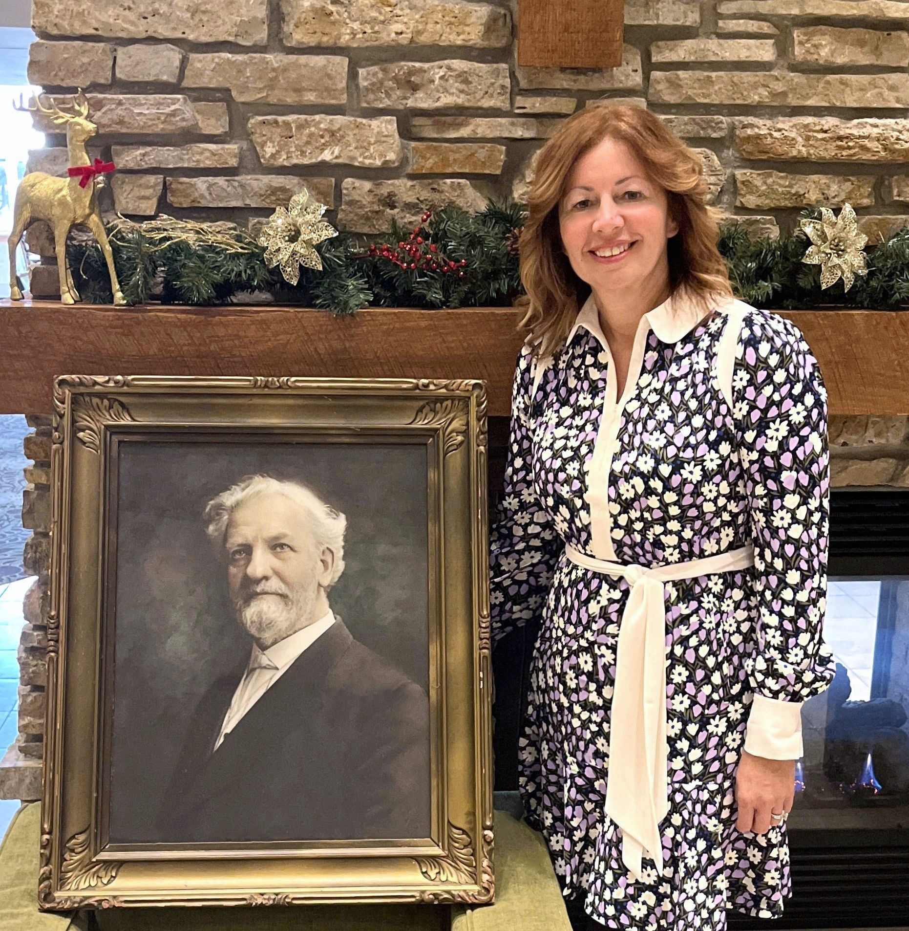 Vera poses next to the portrait of Alfred Anderson, the first chief executive of the organization. Vera poses next to the portrait of Alfred Anderson, the first chief executive of the organization.