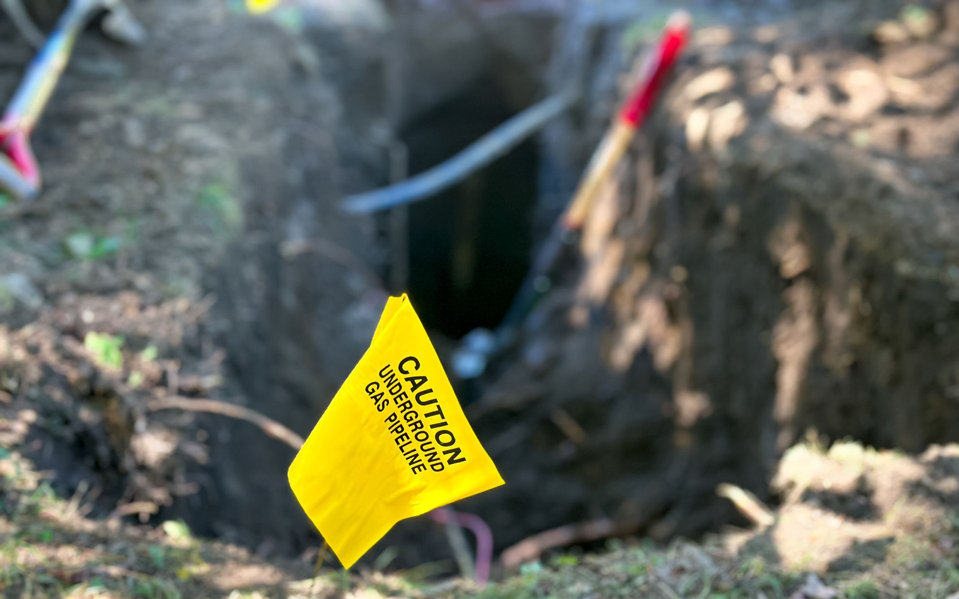 A yellow caution flag is in the dirt near a hole