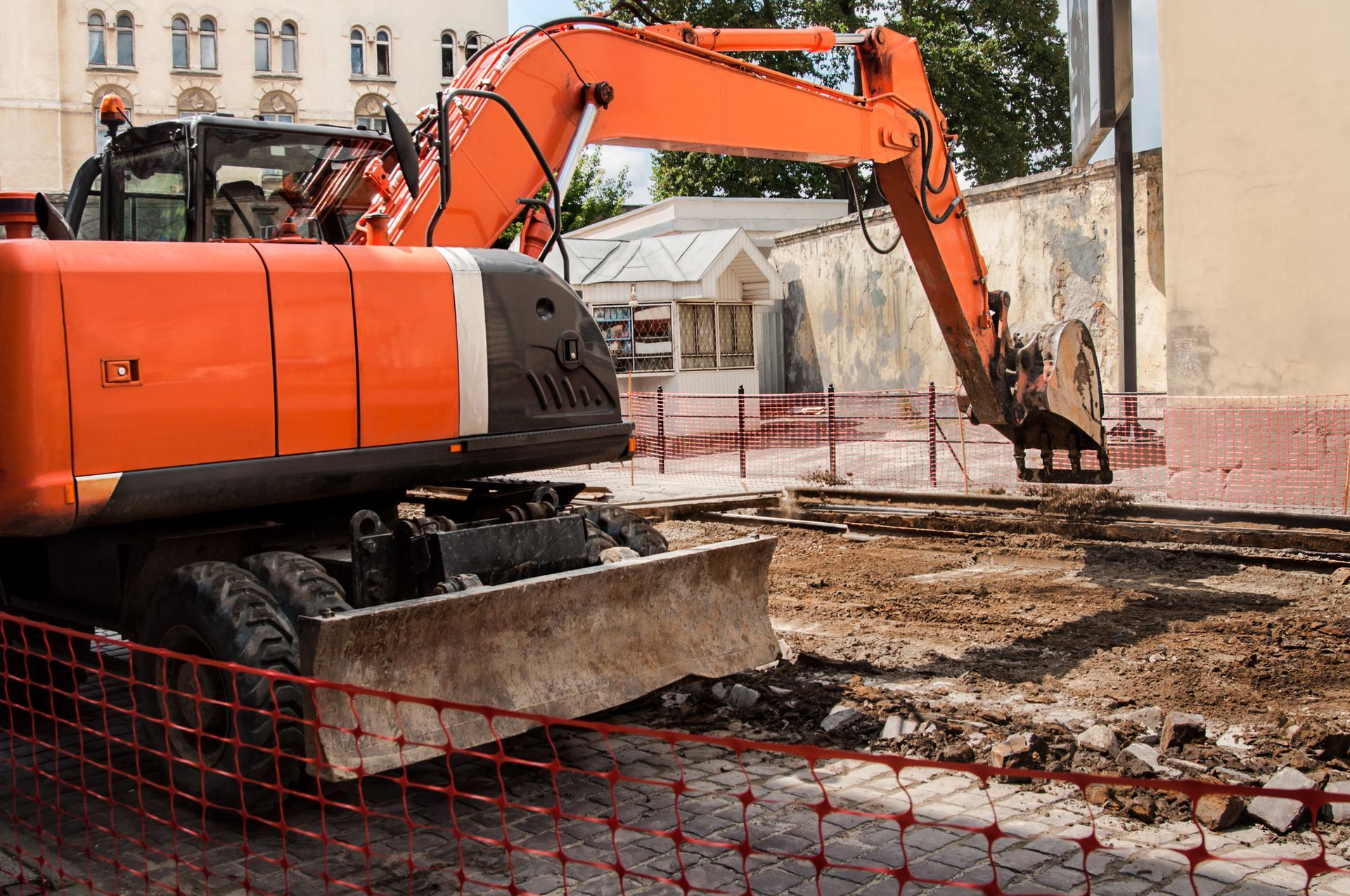 A large orange excavator is working on a construction site. A large orange excavator is working on a construction site.