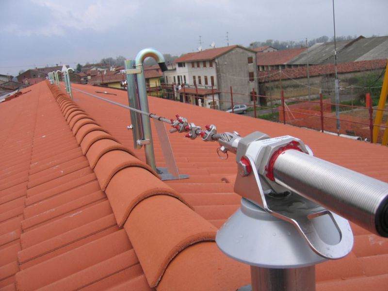 Un tetto di tegole rosse con una linea di sicurezza attaccata