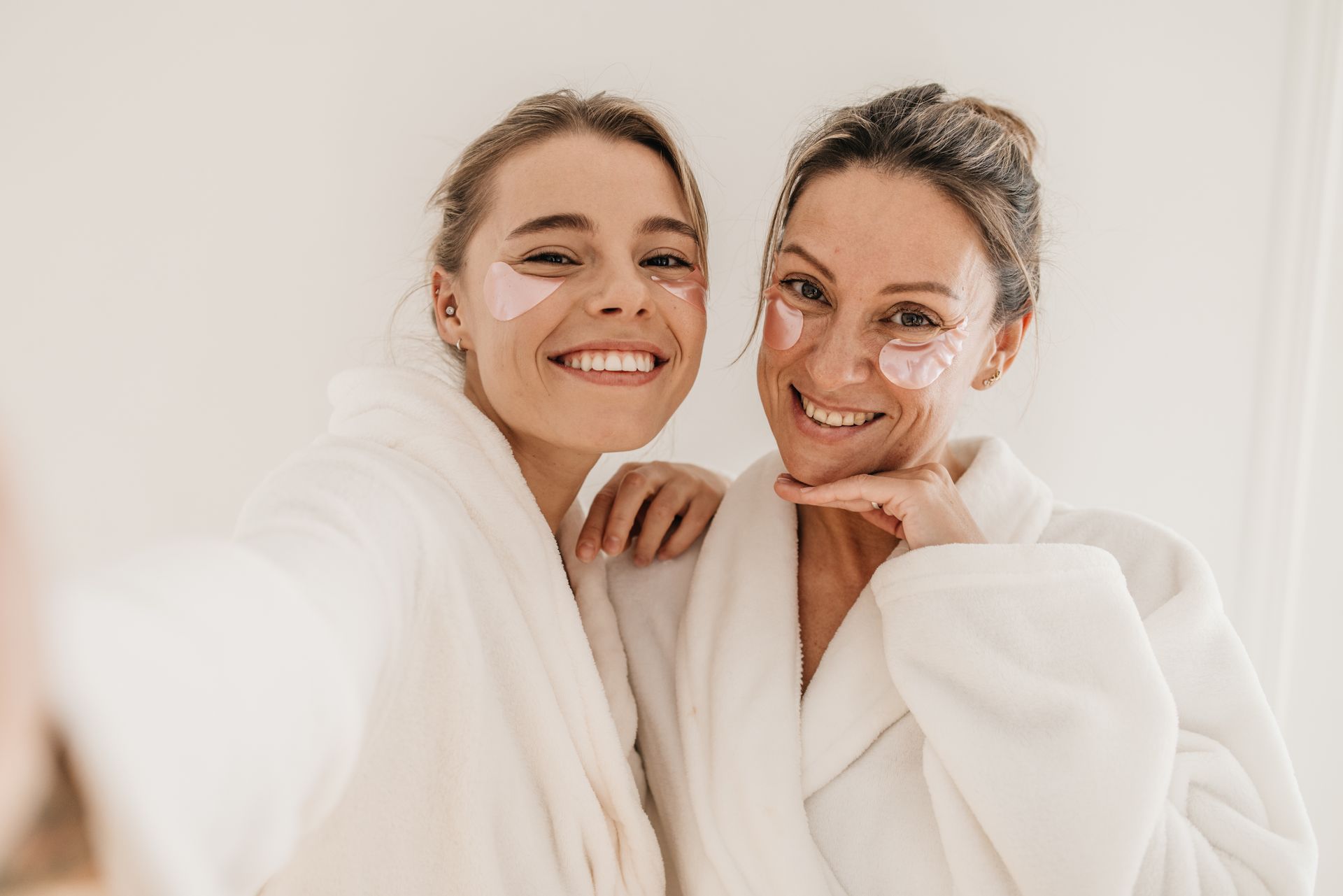 Dos mujeres en bata de baño están paradas una al lado de la otra con mascarillas en sus caras.
