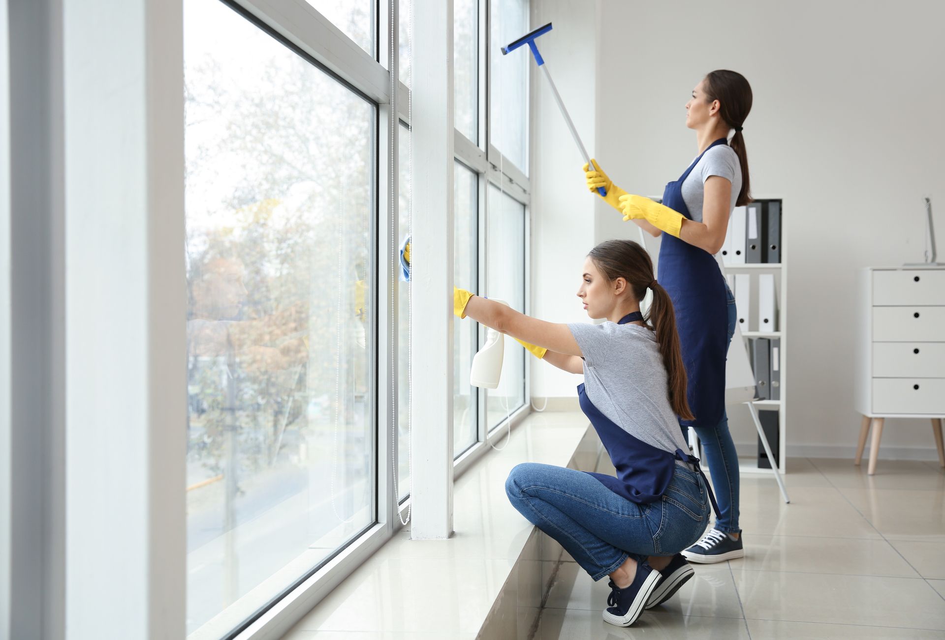 Janitors washing window in office.