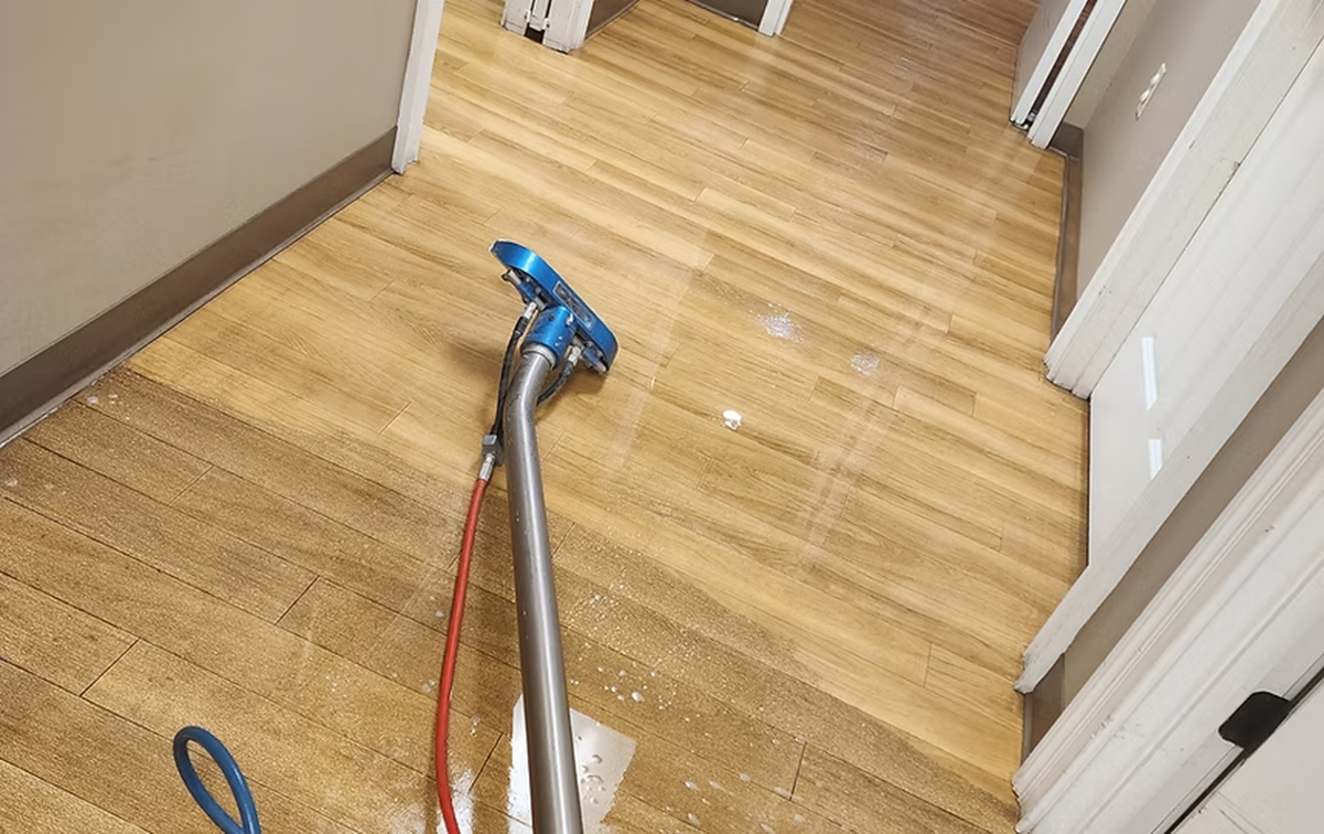 A vacuum cleaner is sitting on a wooden floor in a hallway.