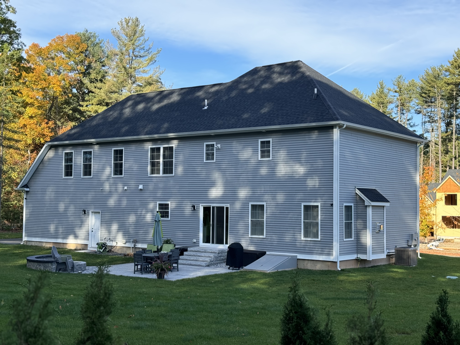 A large gray house with a black roof.