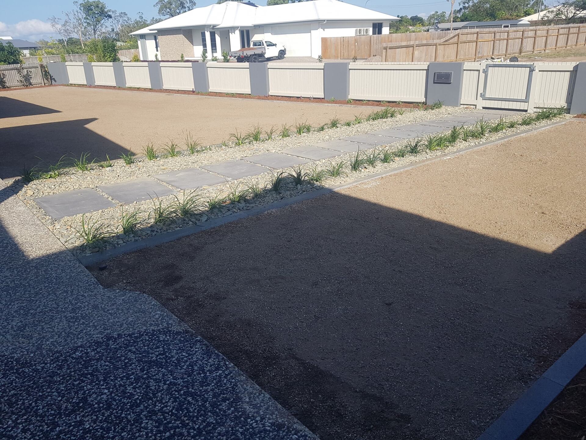 A Driveway With a White House in the Background — Lynams Landscapes Pty Ltd in Jensen, QLD