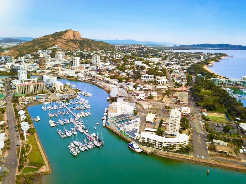 The Sun is Setting Over a City With a Mountain in the Background — Lynams Landscapes Pty Ltd in Castle Hill, QLD