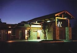 Modern house exterior at dusk with warm lights and stone columns