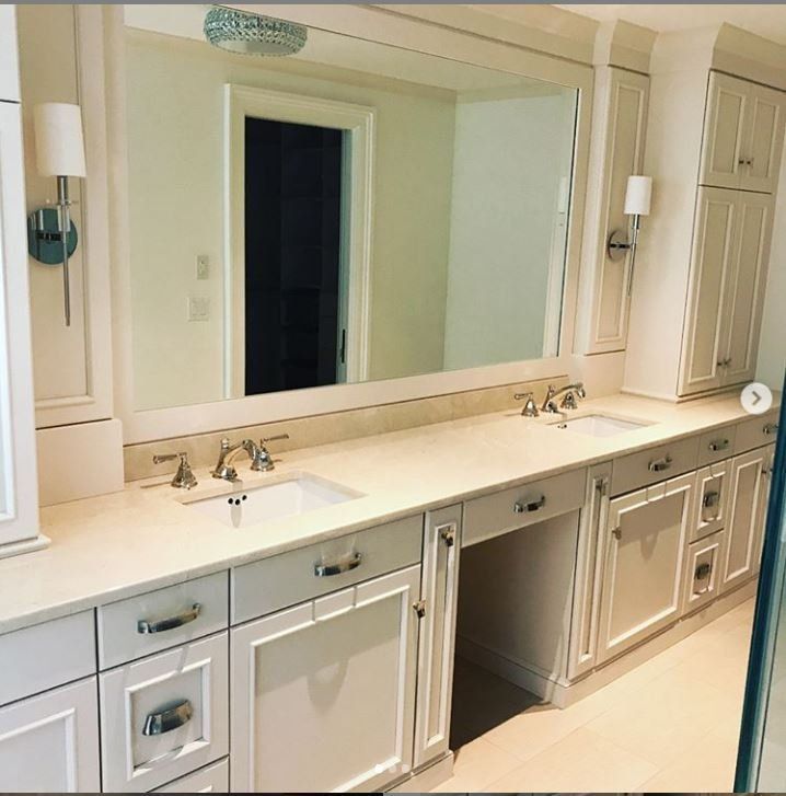 Elegant bathroom vanity with double sinks, large mirror, and white cabinetry.