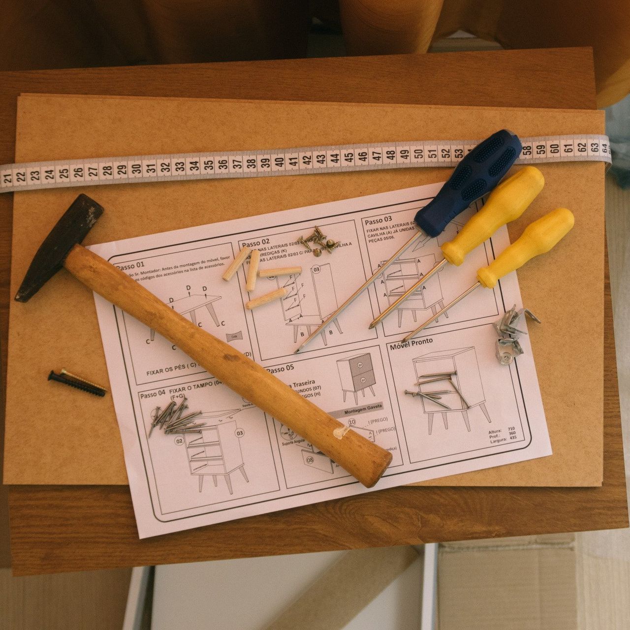 A hammer and screwdrivers are laying on a piece of paper