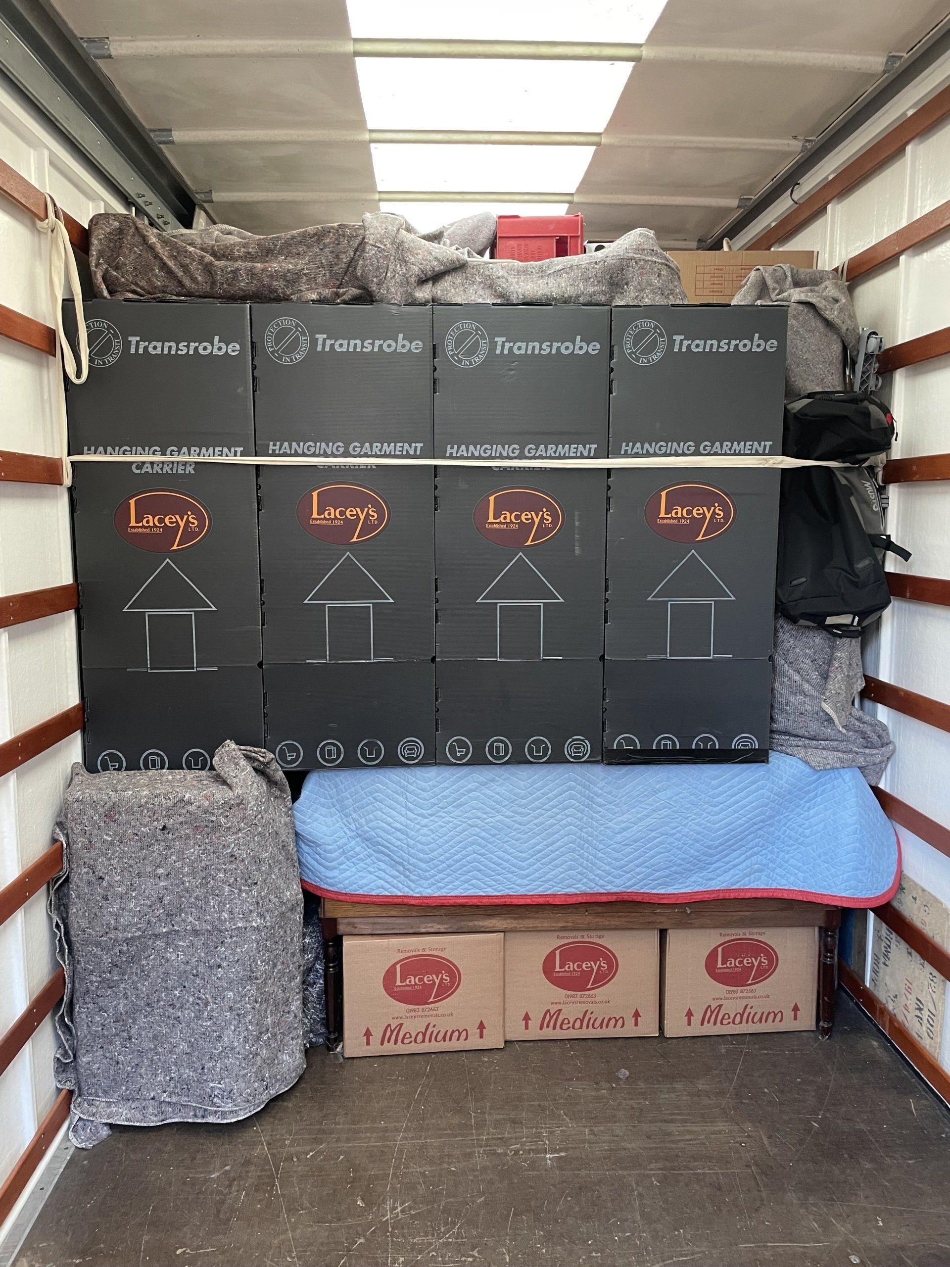 Interior of a moving truck packed with boxes, furniture, and packing materials.