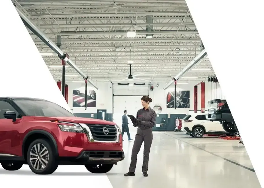 Persona de pie junto a un SUV rojo en una luminosa sala de exposición de coches.